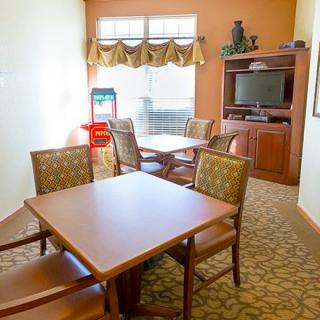 A cozy room with tables, chairs, and a television setup.