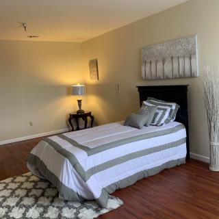 A cozy bedroom with a single bed, modern decor, and warm lighting.