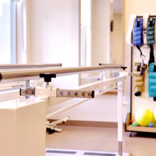 A physical therapy room equipped with parallel bars and rehabilitation tools.