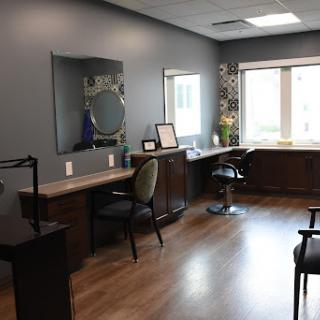 A modern and inviting salon interior featuring sleek furniture and ample natural light.