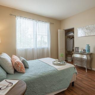 A cozy and bright bedroom with minimalistic decor and a large window letting in natural light.