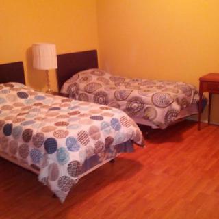 A cozy bedroom with two single beds and a nightstand.