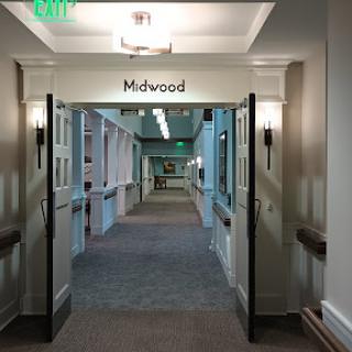 A view of a well-lit hallway with signage leading to 'Midwood'.
