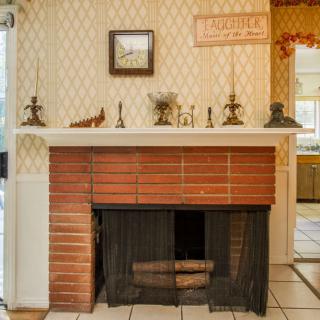 A vintage brick fireplace with a decorated mantel in a cozy home interior.