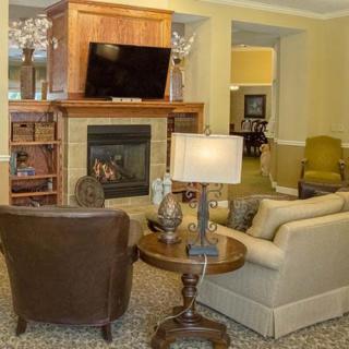 A cozy living room with a fireplace and television, featuring comfortable seating and stylish decor.