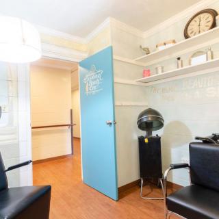 A neatly organized salon interior with styling chairs and hairdressing equipment.