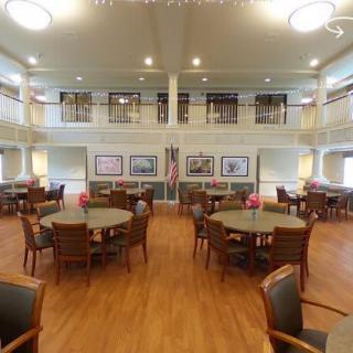 A spacious dining area with multiple tables and chairs, well-lit and decorated.