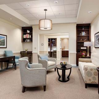 A cozy lounge area with comfortable seating, bookshelves, and a central table.