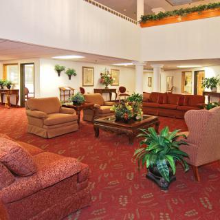 A spacious hotel lobby with comfortable seating and decorative plants.