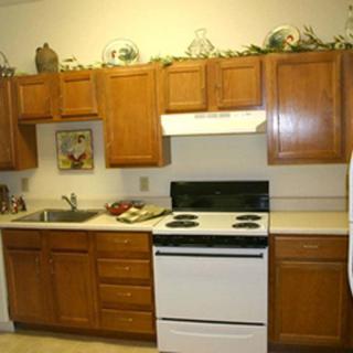 A cozy kitchen with wooden cabinets and a white stove.