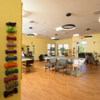 A well-equipped physical therapy and rehabilitation center with a range of exercise equipment and seating areas.