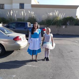 Two girls dressed in costumes, one as a classic character and the other in a fairy-like outfit, enjoying a day out.