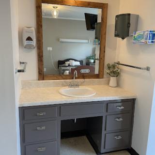 A modern bathroom vanity with a sink and mirror, featuring ample storage space.