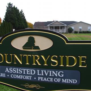 Sign for Countryside Assisted Living facility in a serene outdoor setting.
