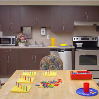 A well-equipped kitchen featuring a table with educational materials and colorful objects, perfect for engaging activities.