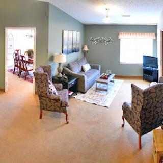 A cozy living room featuring comfortable seating, a television, and warm decorative touches.