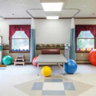A rehabilitation center equipped with exercise balls and a treatment table.