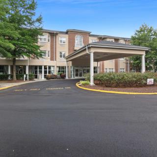 A hotel building with a covered entrance and surrounding trees.