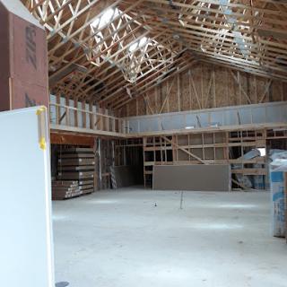 An interior view of a construction site showcasing the wooden framework and open layout.