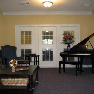 A cozy living room featuring a grand piano and elegant furniture.