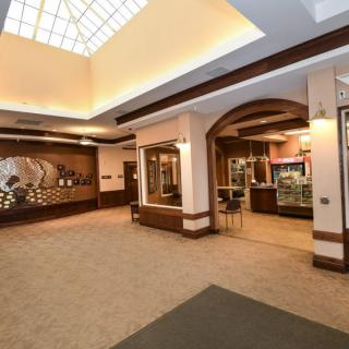 A spacious, well-lit lobby with a reception desk and seating area.