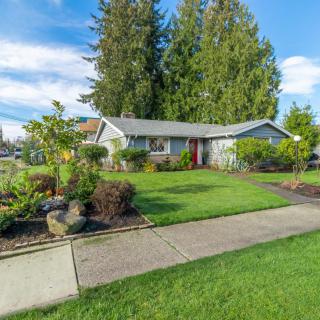 A cozy suburban home with a well-maintained garden and lush green lawn.