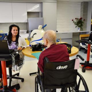 A healthcare professional engaging with a patient in a rehabilitation setting.