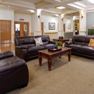 A cozy lobby seating area with leather sofas and a wooden coffee table.
