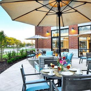 A serene outdoor dining area with umbrella-covered tables and chairs, perfect for a relaxing meal.