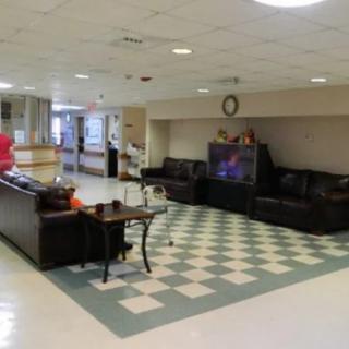 A spacious lobby area featuring comfortable seating and a television.