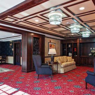 A cozy hotel lobby with classic decor, featuring comfortable seating and elegant lighting.