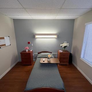 A cozy hospital room featuring a bed, bedside tables, and soft lighting.