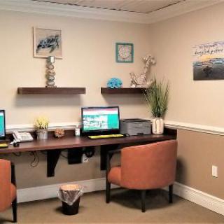 A cozy office workspace with two computers, chairs, and decorative elements.