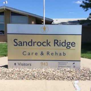 Sign for Sandrock Ridge Care & Rehab outside a building.