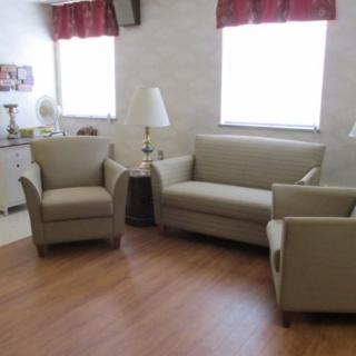 A cozy living room setup with a sofa, two chairs, and lamps.