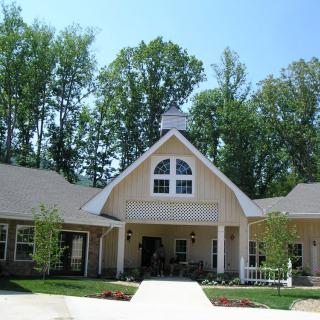 A suburban residential house surrounded by trees.