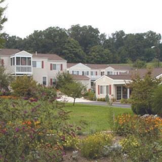 A scenic view of a suburban neighborhood surrounded by lush greenery and gardens.