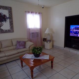 A cozy living room with a sofa, coffee table, and television.