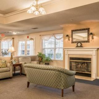 A cozy living room with a fireplace, sofas, and armchairs arranged in a comfortable setting.