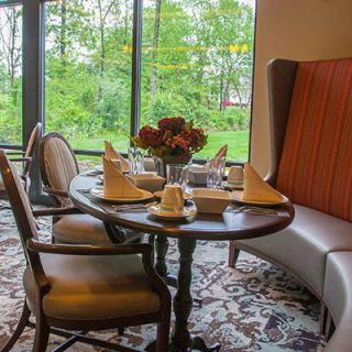 A cozy restaurant dining area with a beautifully set table next to large windows.
