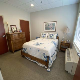 A cozy bedroom with a neatly made bed and wooden furniture.