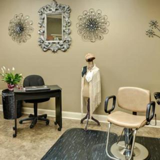 A stylish salon interior with elegant decor, including a hairstyling chair and decorative wall elements.