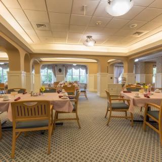 An empty dining room with neatly arranged tables and chairs.