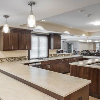 Modern kitchen interior with wooden cabinets and pendant lighting.