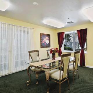 A well-lit dining room with elegant furniture and decorative artwork.