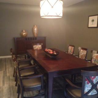 A cozy dining room with a wooden table, chairs, and warm lighting.