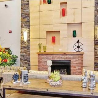 A modern living room with a stylish fireplace, decorative wall accents, and colorful decor.
