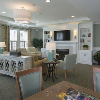 A well-designed living room featuring comfortable seating, a wall-mounted television above a fireplace, and built-in shelving for decor.