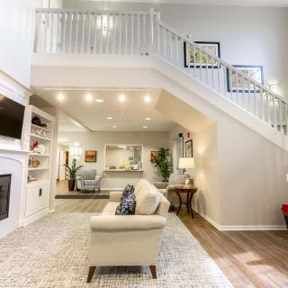 A spacious and modern living room with an elegant staircase and contemporary decor.