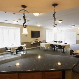 Spacious dining area with multiple tables, a TV, and decorative lighting.